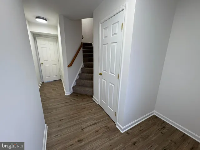 a view of a hallway with wooden floor and entryway