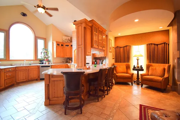 a large kitchen with stainless steel appliances a stove a sink dishwasher and wooden cabinets