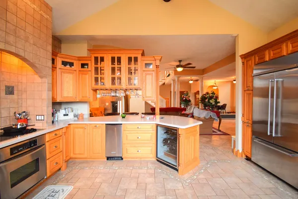 a large kitchen with stainless steel appliances granite countertop a refrigerator and a stove top oven