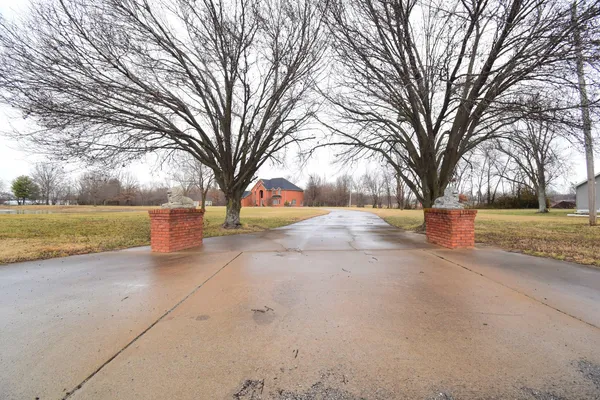 a view of a big house with a yard and large tree