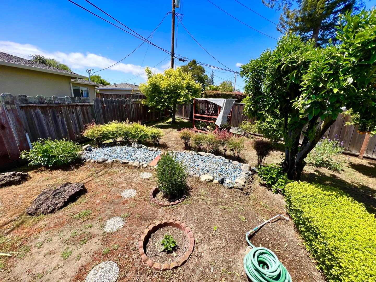 696 McCarty Avenue Mountain View, CA 94041 - Photo 24 of 31 a view of a backyard with table and chairs under an umbrella
