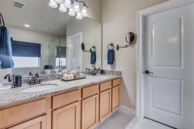 a bathroom with a granite countertop sink a mirror and a shower
