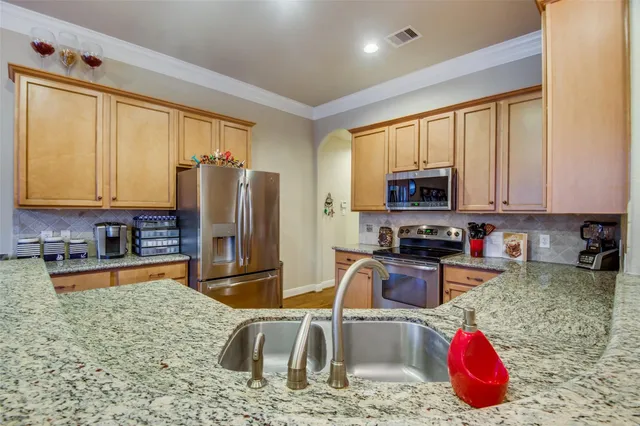 a kitchen with stainless steel appliances granite countertop a sink stove and refrigerator