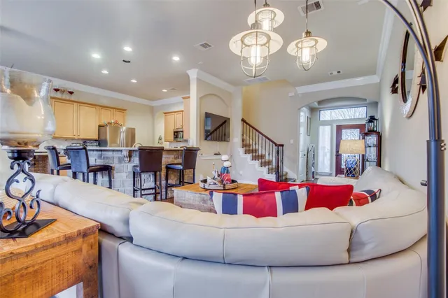 a living room with furniture kitchen view and a chandelier