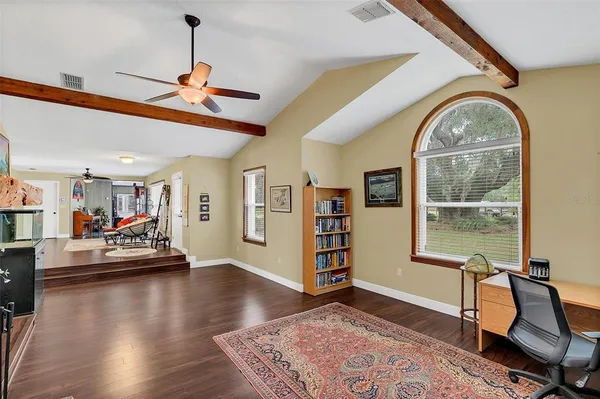 a dining hall with stainless steel appliances granite countertop a table and chairs with wooden floor