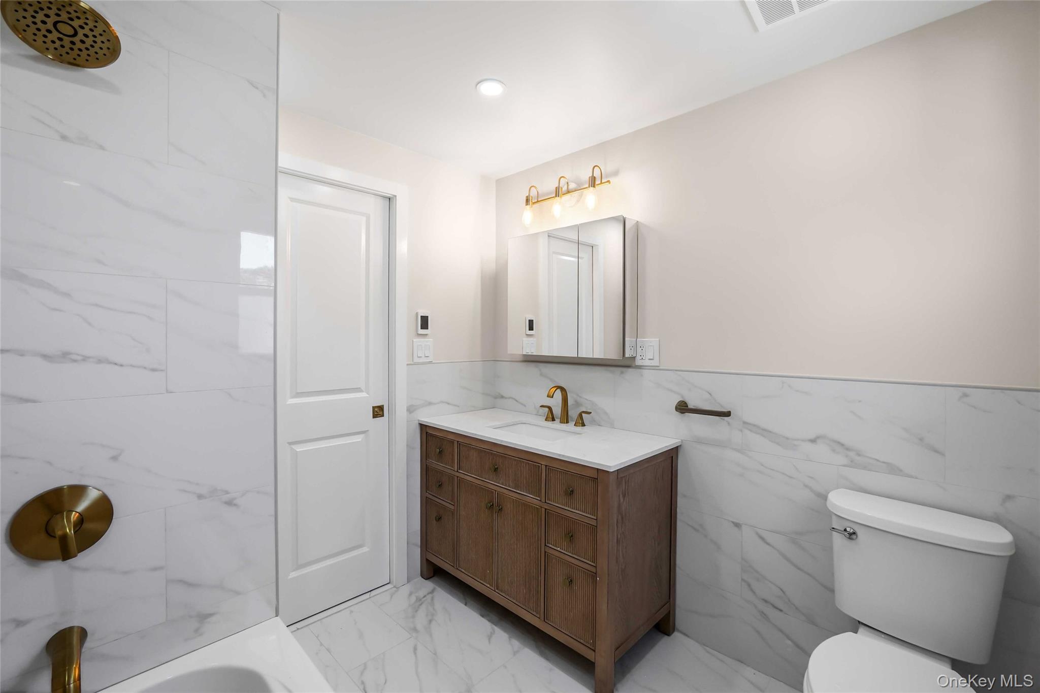 123 East Maple Street Valley Stream, NY 11580 - Photo 6 of 11 a bathroom with a double vanity sink toilet and mirror