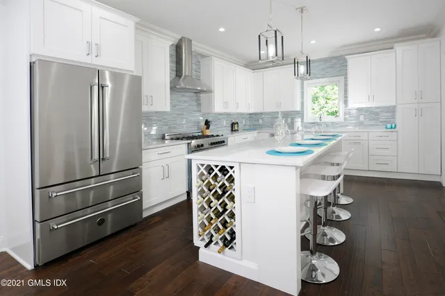 a kitchen with stainless steel appliances granite countertop a sink a stove and a refrigerator