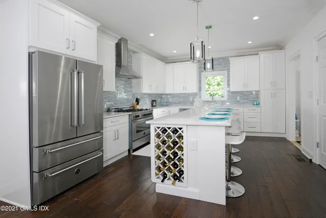 a kitchen with granite countertop white cabinets and stainless steel appliances