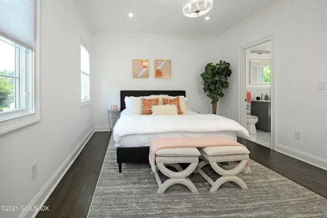 a bedroom with a bed and a table in it with window