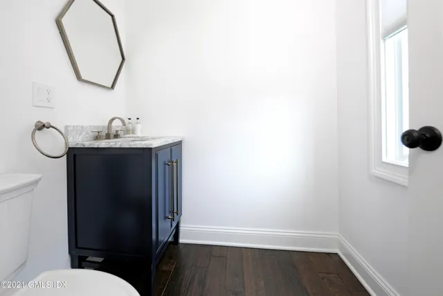 a bathroom with a sink toilet and a mirror