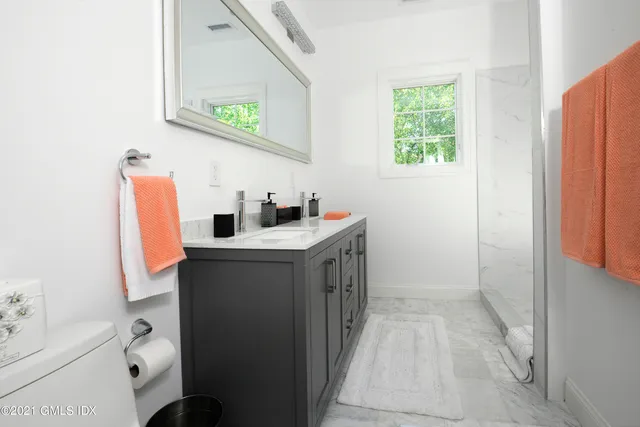 a bathroom with a sink mirror vanity and toilet