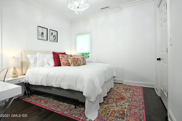 a bed sitting in a bedroom next to a lamp