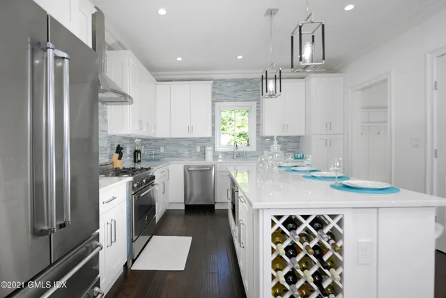a kitchen with stainless steel appliances granite countertop a sink stove and refrigerator
