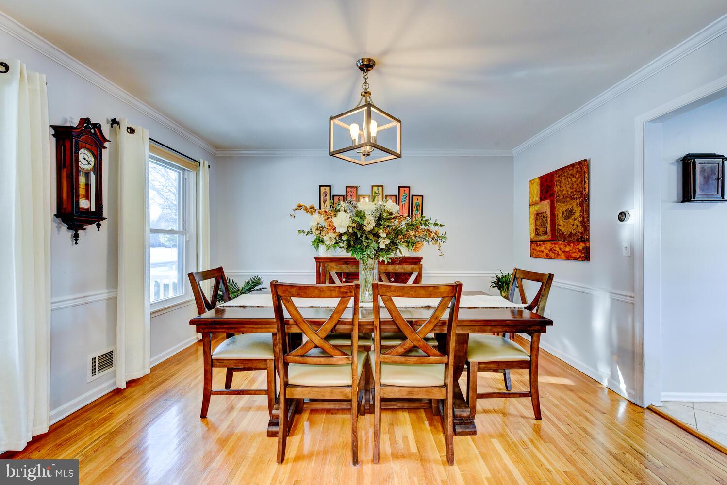 374 Village Road East Princeton Junction, NJ 08550 - Photo 15 of 54 a dining room with wooden floor a chandelier a glass table and chairs