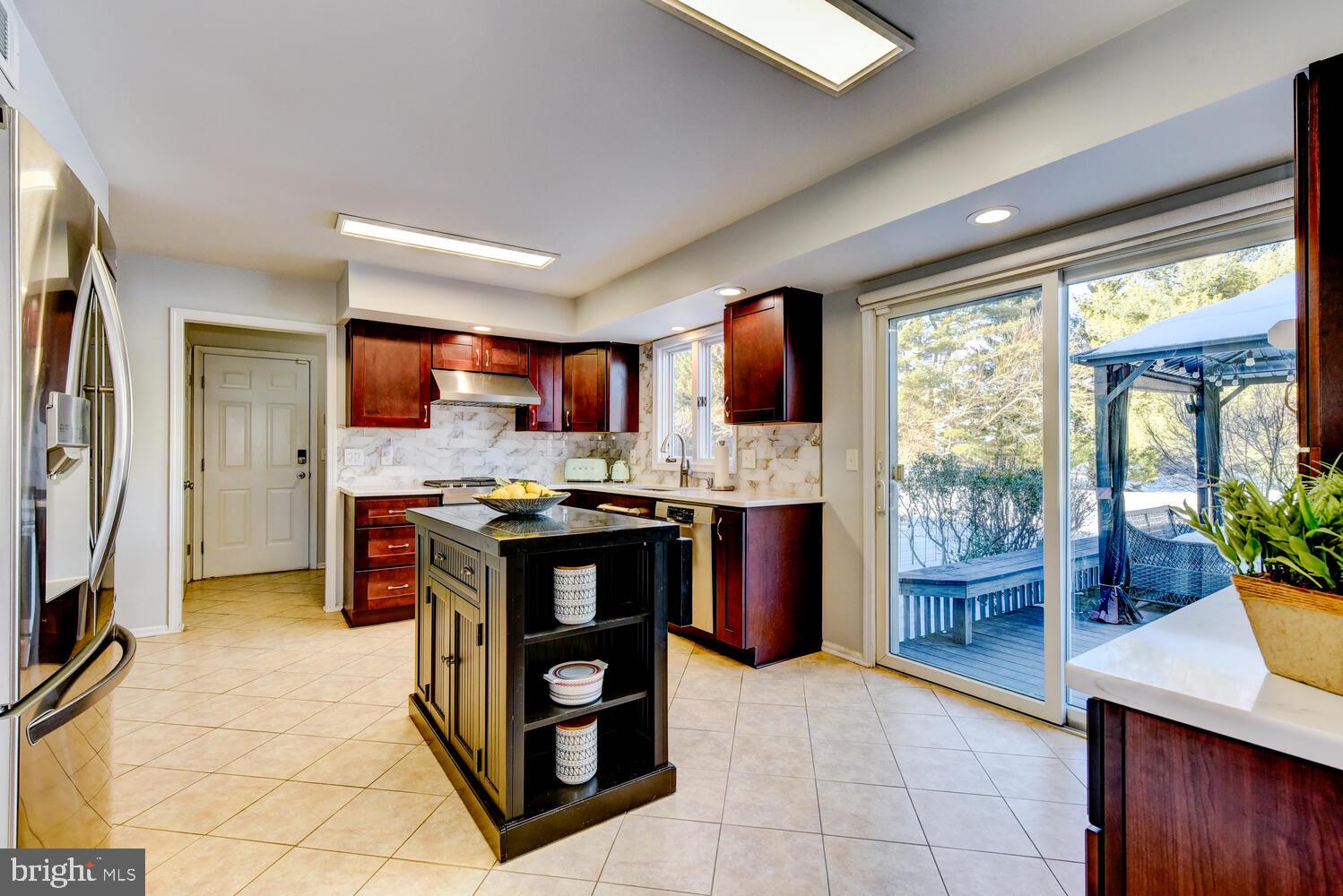 374 Village Road East Princeton Junction, NJ 08550 - Photo 21 of 54 a kitchen with stainless steel appliances kitchen island granite countertop a refrigerator and a sink