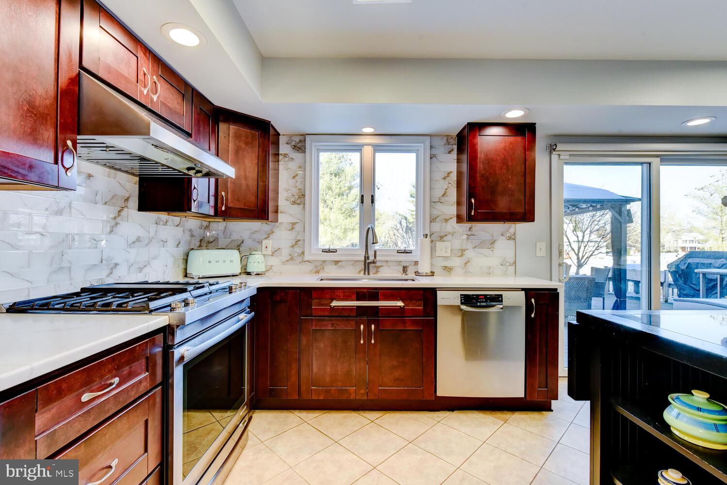 374 Village Road East Princeton Junction, NJ 08550 - Photo 23 of 54 a kitchen with stainless steel appliances granite countertop a stove a sink and a microwave
