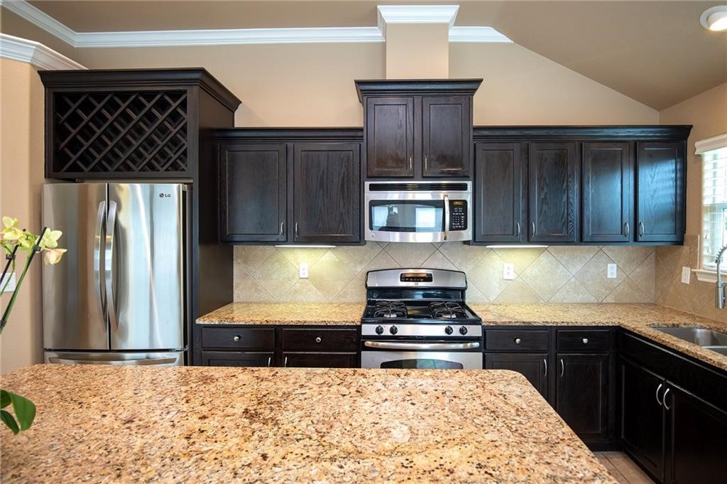3921 Las Bahias Drive Corpus Christi, TX 78414 - Photo 7 of 16 a kitchen with wooden cabinets and a stove top oven