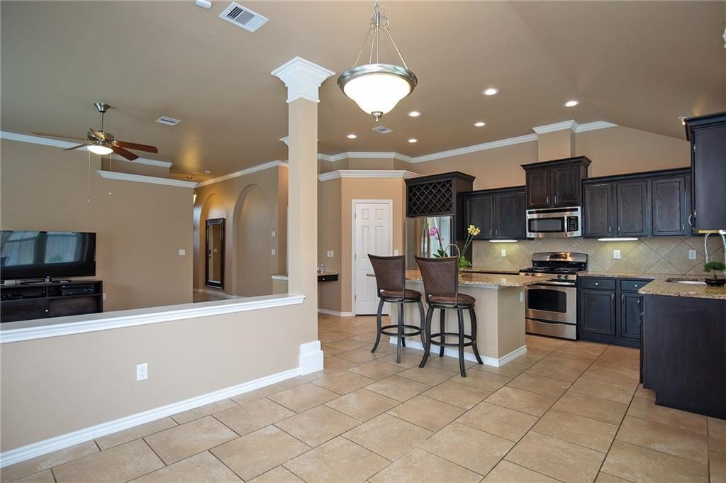 3921 Las Bahias Drive Corpus Christi, TX 78414 - Photo 8 of 16 a kitchen with stainless steel appliances granite countertop a stove top oven a sink a dining table and chairs