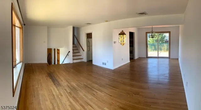a view of a livingroom with wooden floor and a window