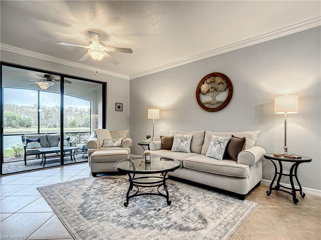 9554 Trevi Court, Unit 4715 Naples, FL 34113 - Photo 24 of 49 a living room with furniture a clock and a large window