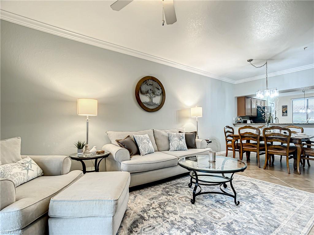 9554 Trevi Court, Unit 4715 Naples, FL 34113 - Photo 25 of 49 a living room with furniture a clock on wall and a table