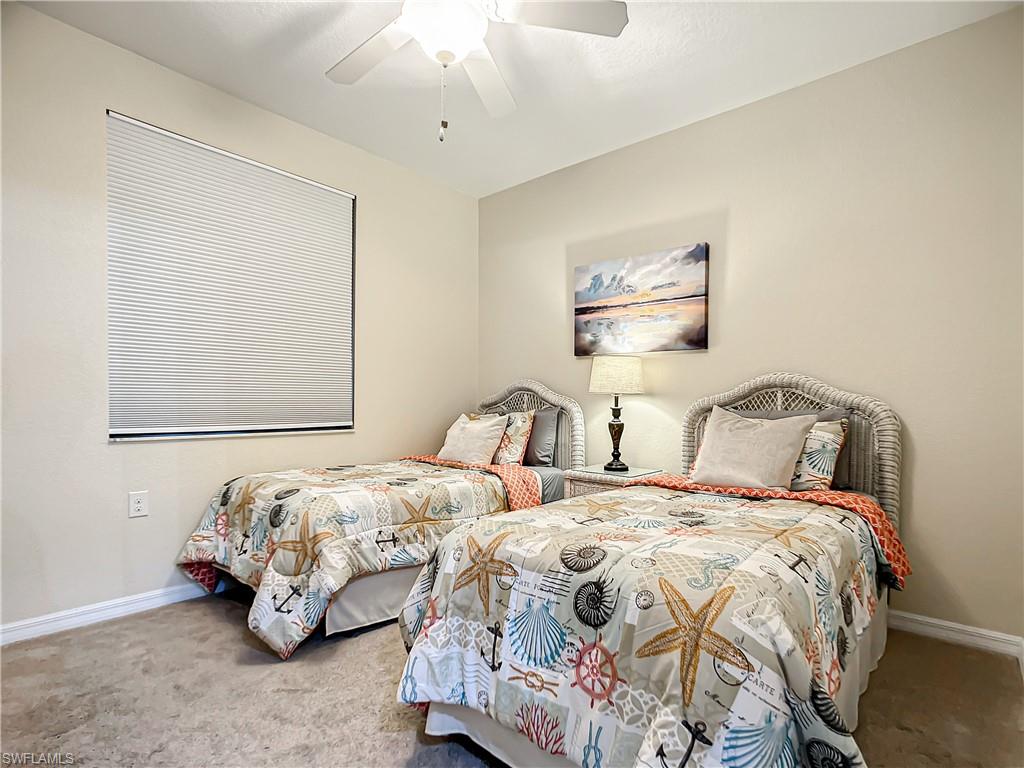 9554 Trevi Court, Unit 4715 Naples, FL 34113 - Photo 31 of 49 a bedroom with two beds and a chandelier