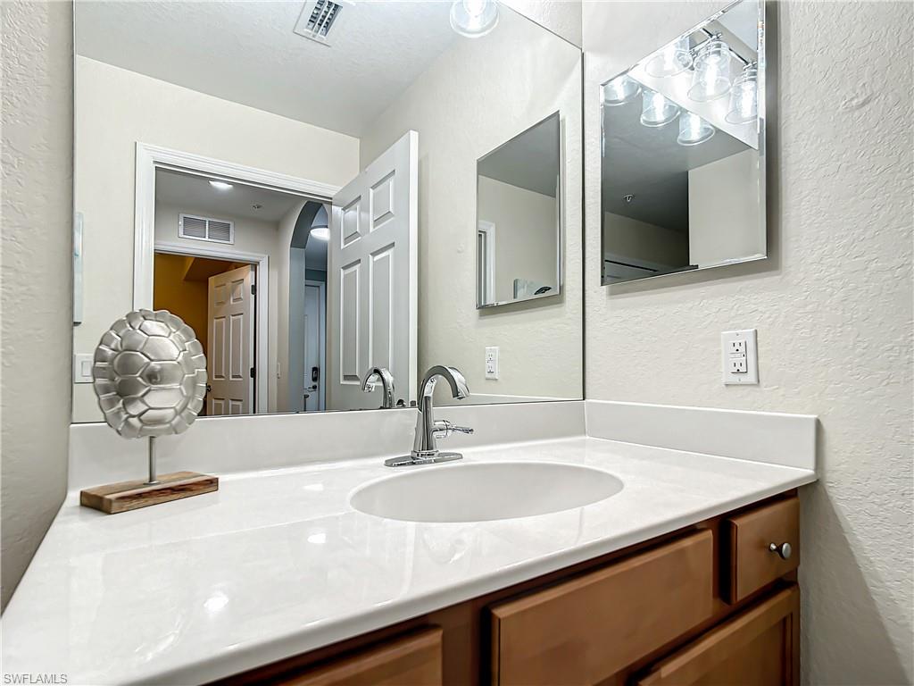 9554 Trevi Court, Unit 4715 Naples, FL 34113 - Photo 35 of 49 a bathroom with a sink and a mirror
