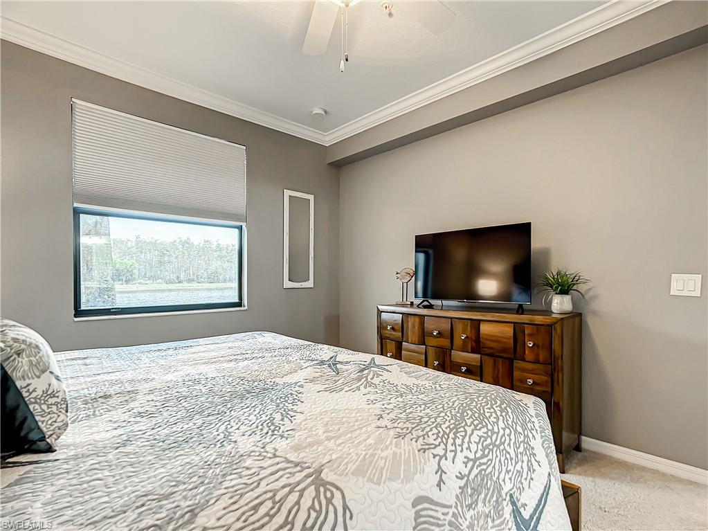 9554 Trevi Court, Unit 4715 Naples, FL 34113 - Photo 38 of 49 a bedroom with a bed and a flat screen tv