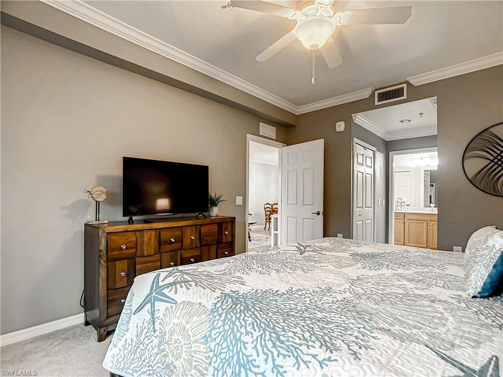 9554 Trevi Court, Unit 4715 Naples, FL 34113 - Photo 41 of 49 a bedroom with a bed and a flat screen tv