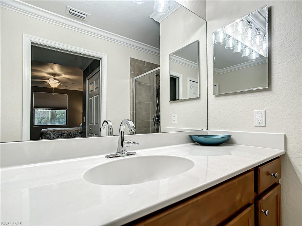 9554 Trevi Court, Unit 4715 Naples, FL 34113 - Photo 43 of 49 a bathroom with double vanity sinks and a mirror