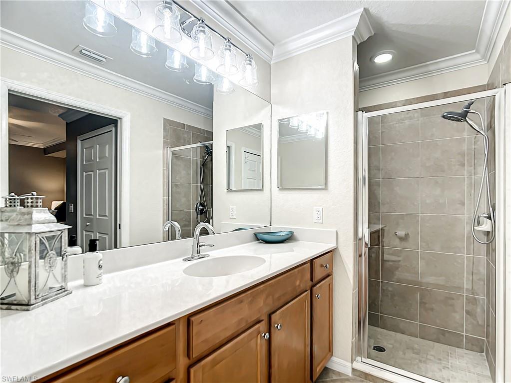 9554 Trevi Court, Unit 4715 Naples, FL 34113 - Photo 44 of 49 a bathroom with a sink double vanity and shower