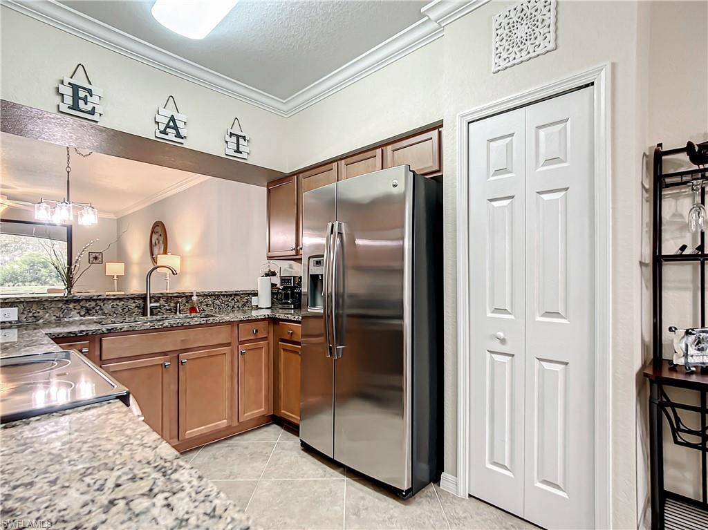 9554 Trevi Court, Unit 4715 Naples, FL 34113 - Photo 6 of 49 a kitchen with stainless steel appliances granite countertop a refrigerator and a sink