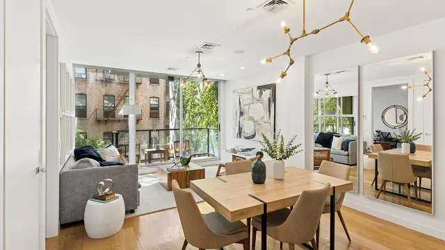 a view of a dining room and livingroom with furniture wooden floor a chandelier