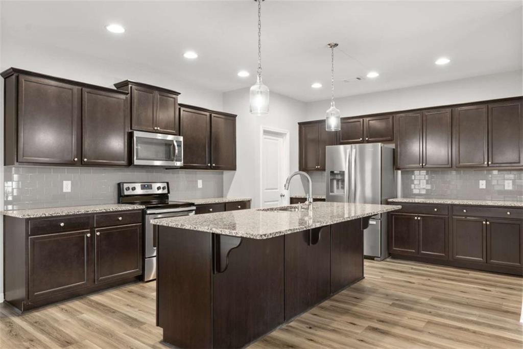 6021 Harbour Mist Drive Flowery Branch, GA 30542 - Photo 14 of 36 a kitchen with stainless steel appliances granite countertop refrigerator a sink a stove a microwave and wooden cabinets