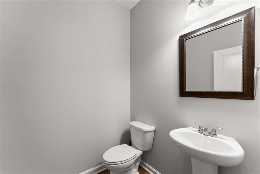 6021 Harbour Mist Drive Flowery Branch, GA 30542 - Photo 17 of 36 a bathroom with a toilet sink and mirror