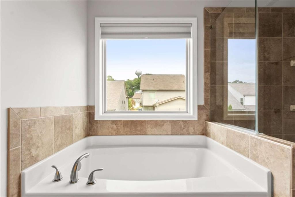 6021 Harbour Mist Drive Flowery Branch, GA 30542 - Photo 32 of 36 a white bath tub sitting next to a window