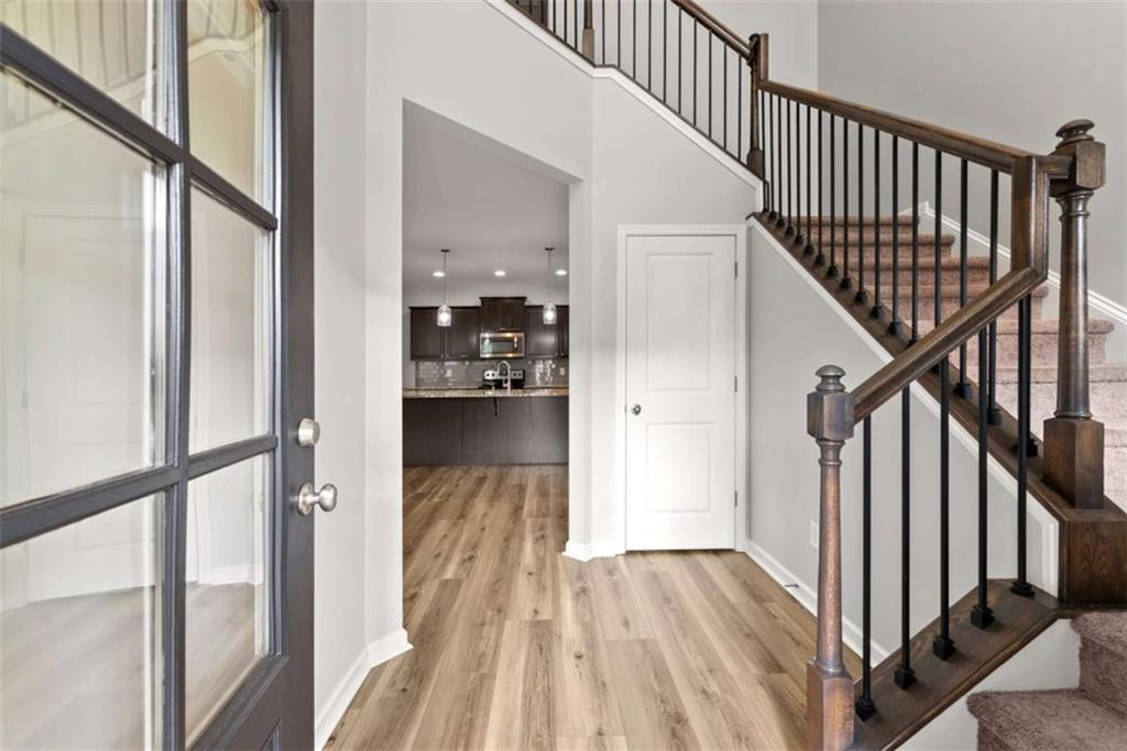 6021 Harbour Mist Drive Flowery Branch, GA 30542 - Photo 4 of 36 a view of hallway with wooden floor and stairs