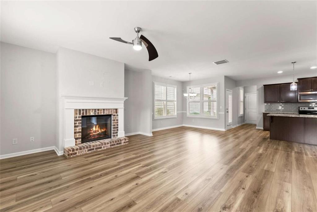 6021 Harbour Mist Drive Flowery Branch, GA 30542 - Photo 5 of 36 a view of empty room with wooden floor and fireplace