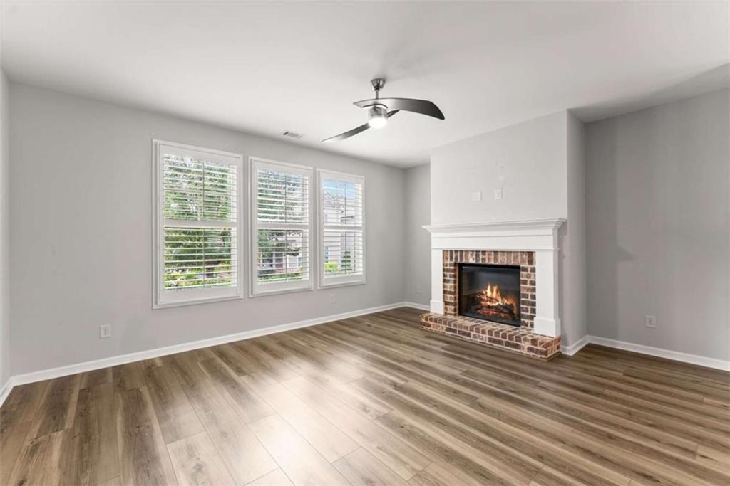 6021 Harbour Mist Drive Flowery Branch, GA 30542 - Photo 6 of 36 a view of an empty room with wooden floor fireplace and a window