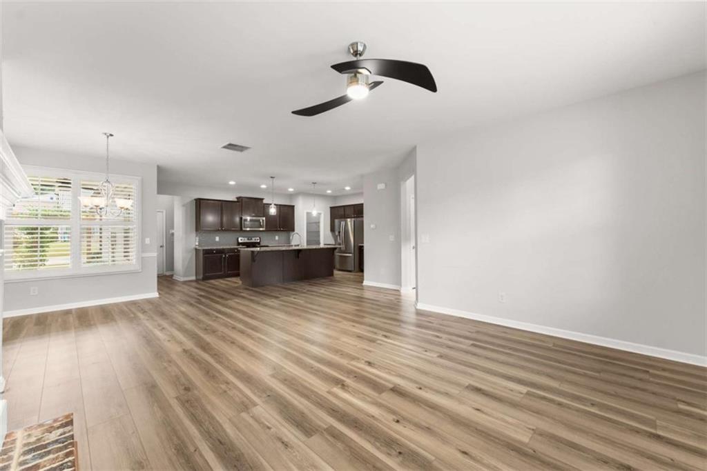 6021 Harbour Mist Drive Flowery Branch, GA 30542 - Photo 7 of 36 wooden floor in an empty room with a window