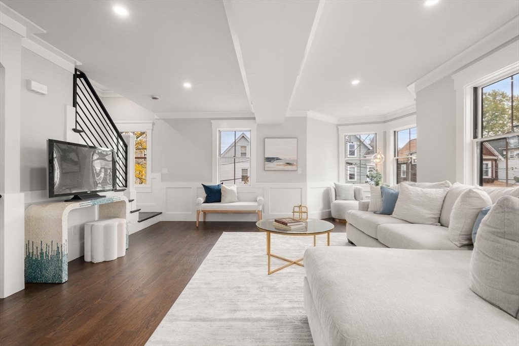 a living room with furniture wooden floor and a flat screen tv