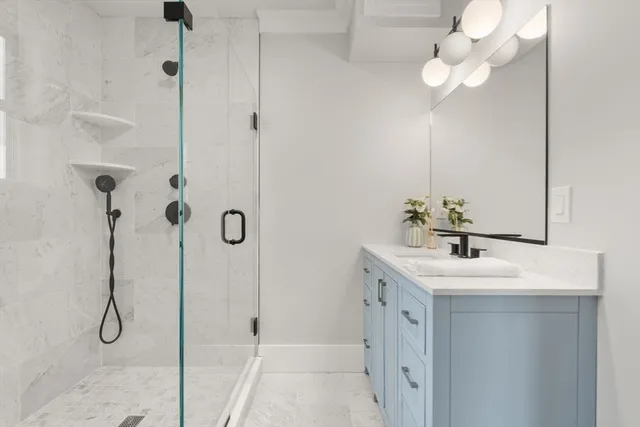 a bathroom with a sink a mirror and a shower