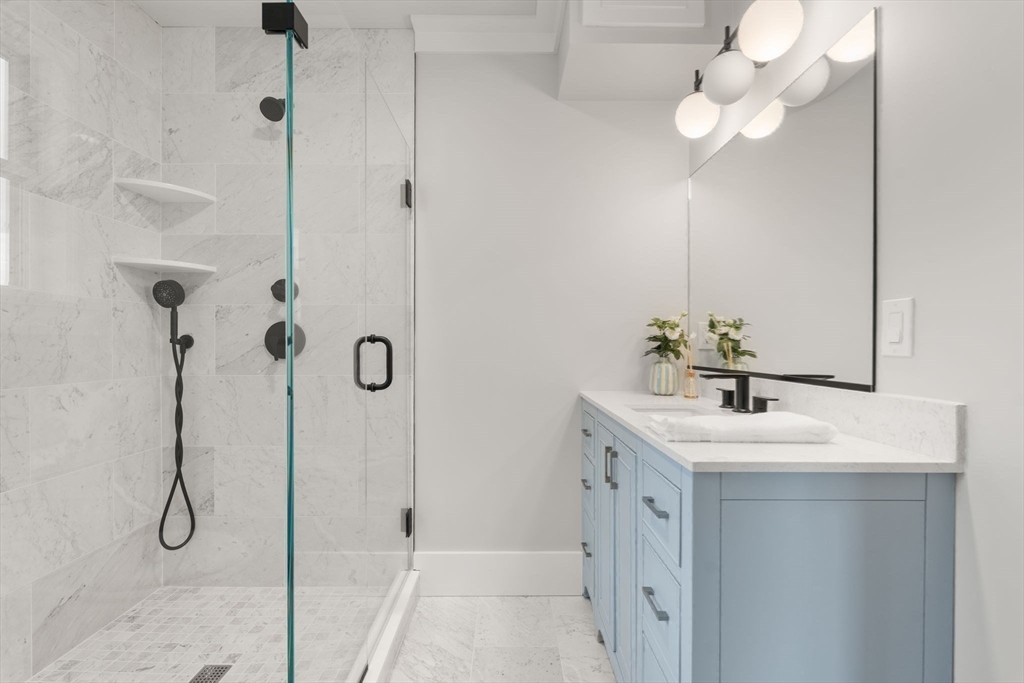 11 Macarthur Street, Unit B Somerville, MA 02145 - Photo 17 of 28 a bathroom with a sink a mirror and a shower