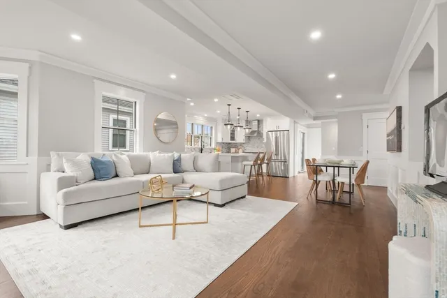 a living room with furniture and a dining table with wooden floor