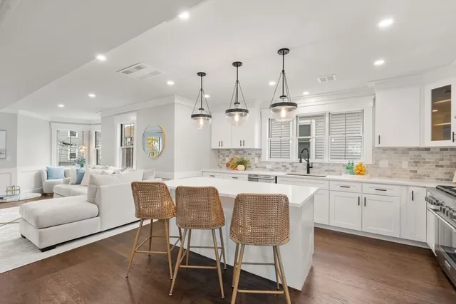 a large kitchen with granite countertop lots of white furniture and appliances