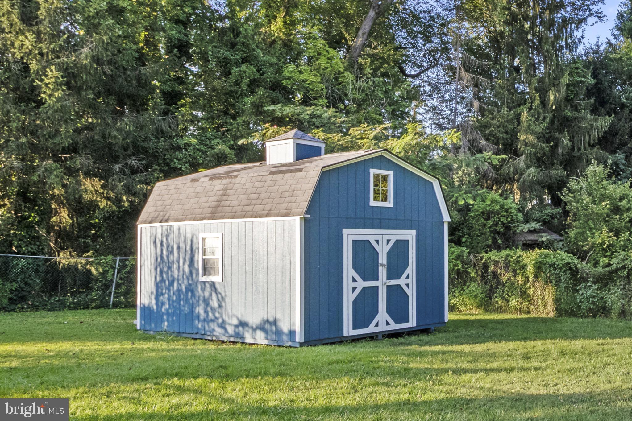 113 Risdon Street Mount Holly, NJ 08060 - Photo 25 of 25 Charming blue shed nestled in lush greenery.