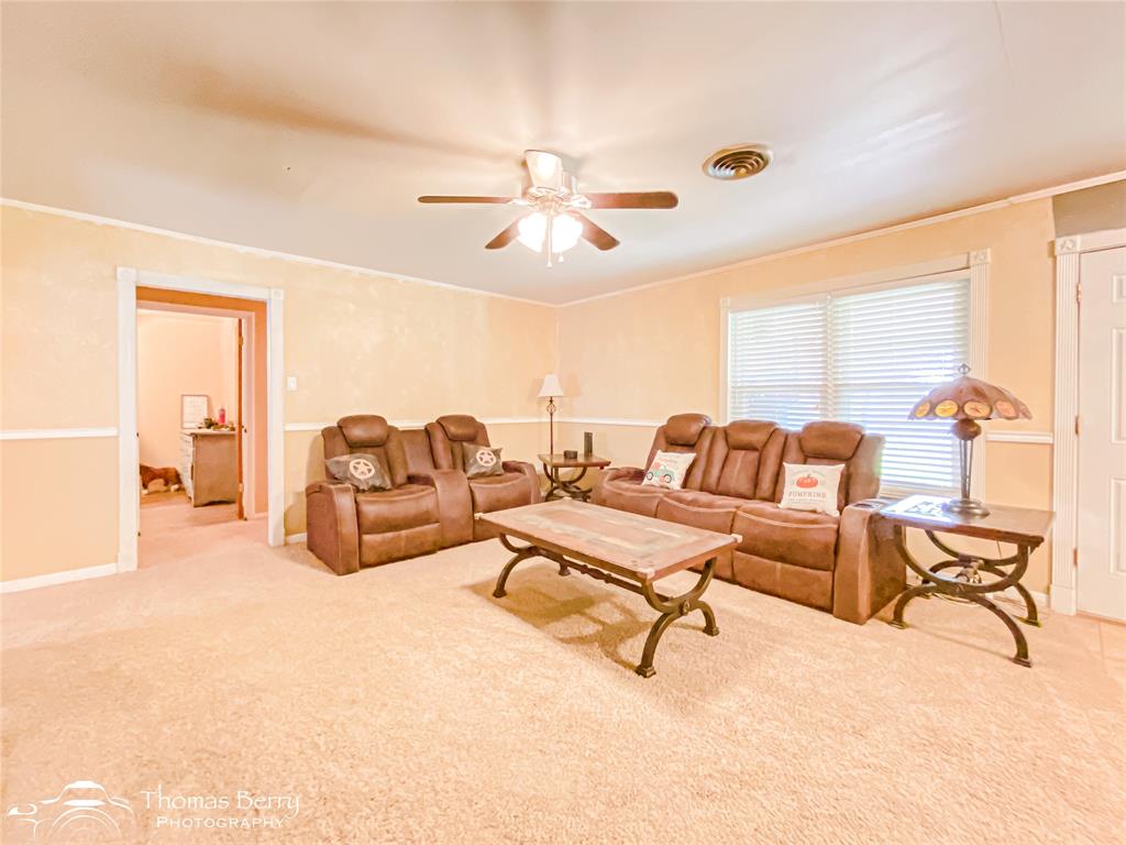 1104 Hickory Street Roscoe, TX 79545 - Photo 7 of 22 Living room featuring carpet, crown molding, and ceiling fan