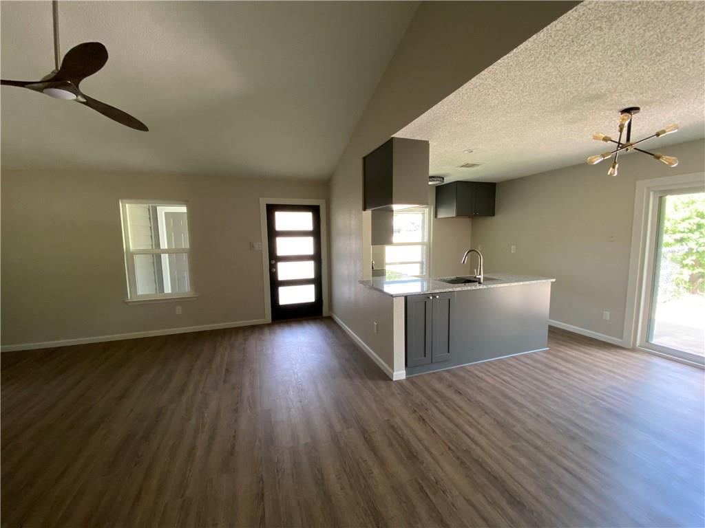 1715 Shadowview Drive, Unit B Austin, TX 78758 - Photo 13 of 28 An inviting open-concept living area with a kitchen island flows into a well-lit space featuring elegant flooring.