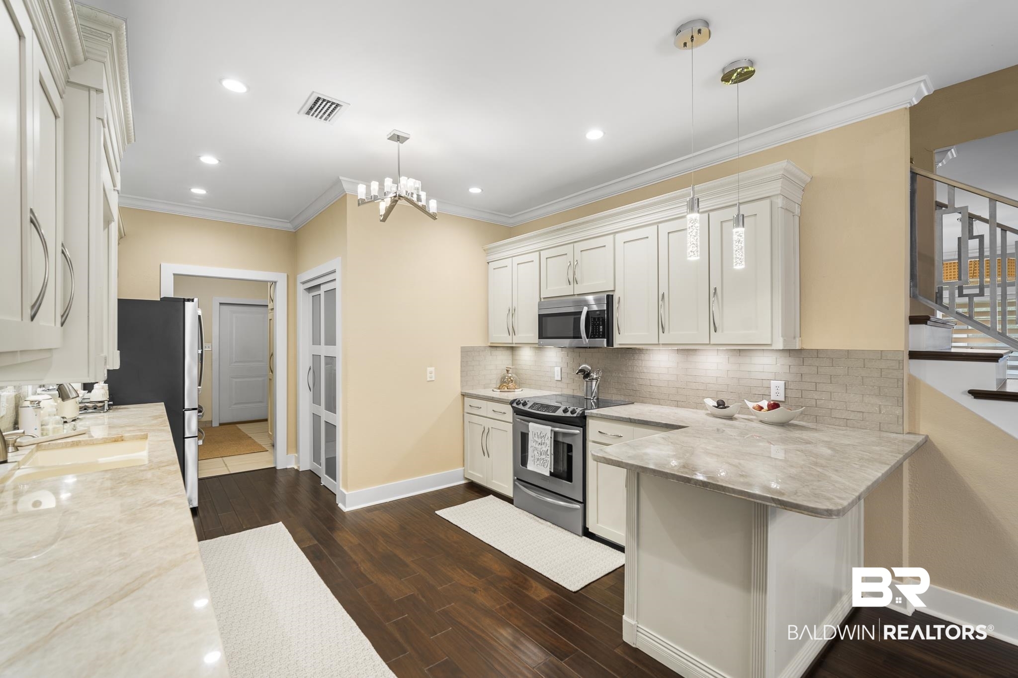 178 Lakeview Loop Daphne, AL 36526 - Photo 12 of 43 Kitchen with light stone counters, crown molding, white cabinetry, appliances with stainless steel finishes, and hanging light fixtures