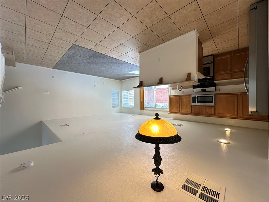 7305 Prussian Green Street Las Vegas, NV 89139 - Photo 5 of 23 A well-lit loft area transitions into a practical kitchen space with classic cabinetry.